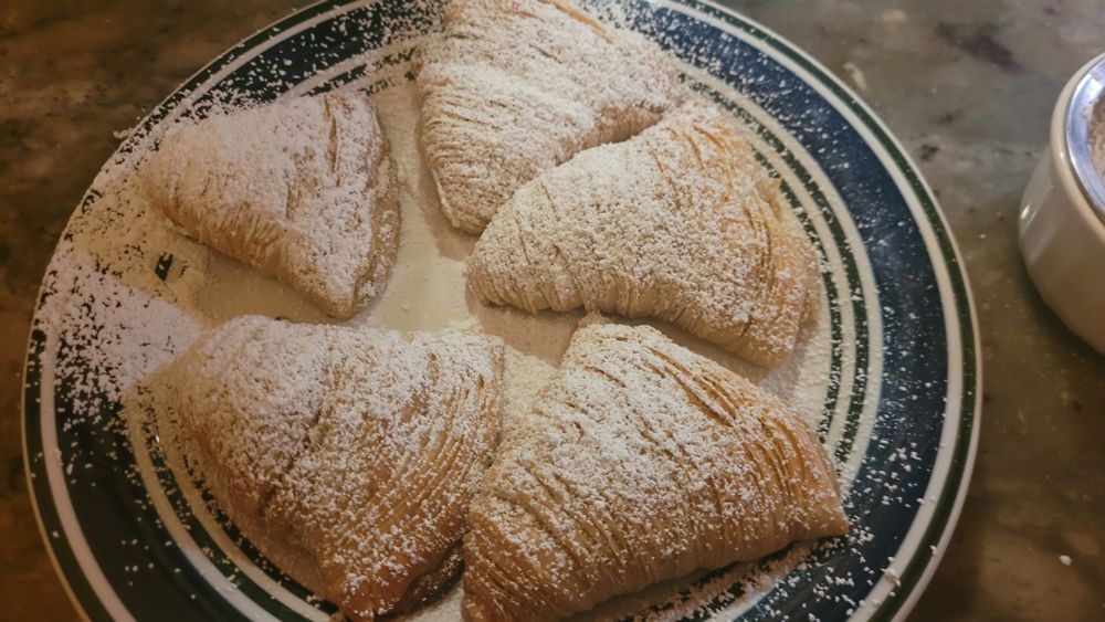 a plate of sfogliatelle dusted in powdered sugar