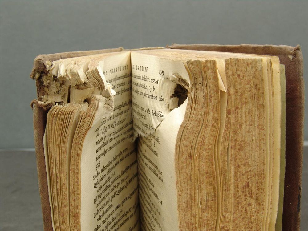 Un viejo libro perforado por un balazo. Fuente: Biblioteca Histórica, Universidad Complutense de Madrid.