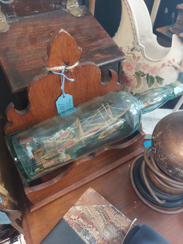 Photo of ship in a bottle on wooden shelf 