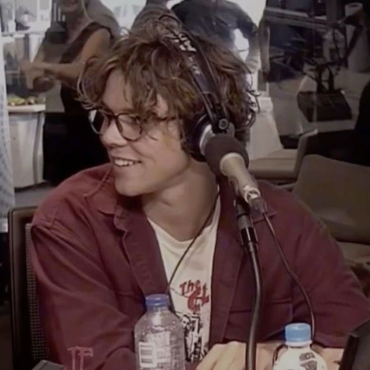 Ashton Irwin wearing headphones, looking away from the camera.