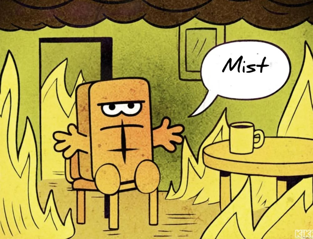 Das Bild zeigt eine animierte Szene mit einem quadratischen, braunen Brotcharakter (Bernd das Brot), der auf einem Stuhl sitzt und mit einem unzufriedenen Gesichtsausdruck die Arme ausstreckt. Der Charakter befindet sich in einem Raum, der von Flammen umgeben ist, was auf ein Feuer hinweist. Im Hintergrund ist ein offener Türrahmen und ein Fenster zu sehen. Auf einem kleinen runden Tisch neben dem Charakter steht eine Tasse. Der Charakter spricht mit einem Sprechblasen, in dem das Wort "Mist" steht. Die Szene ist in einem Comic-Stil gehalten, mit kräftigen Farben und einfachen Linien.