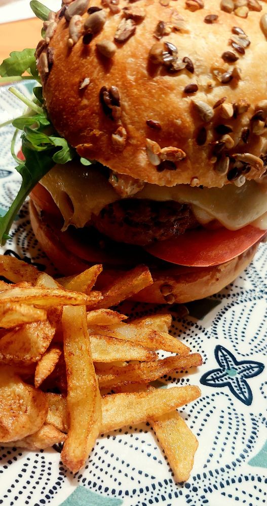 Hamburger et frites maison dans une assiette aux motifs verts