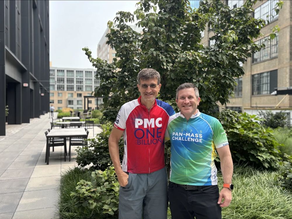 Two men standing on a patio wearing Pan-Mass Challenge shirts