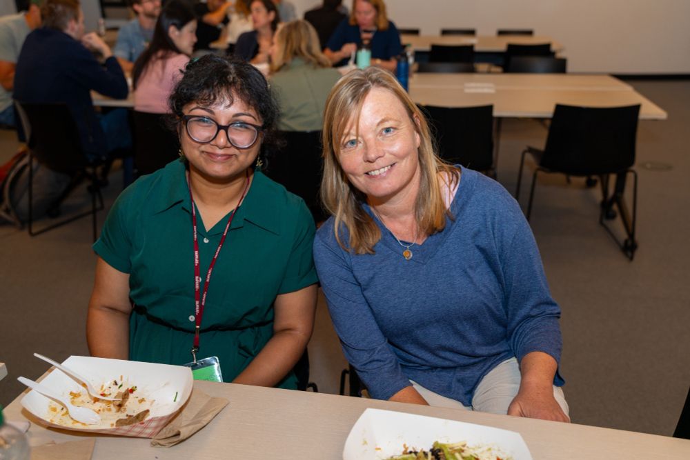 Two people sitting at a table and smiling