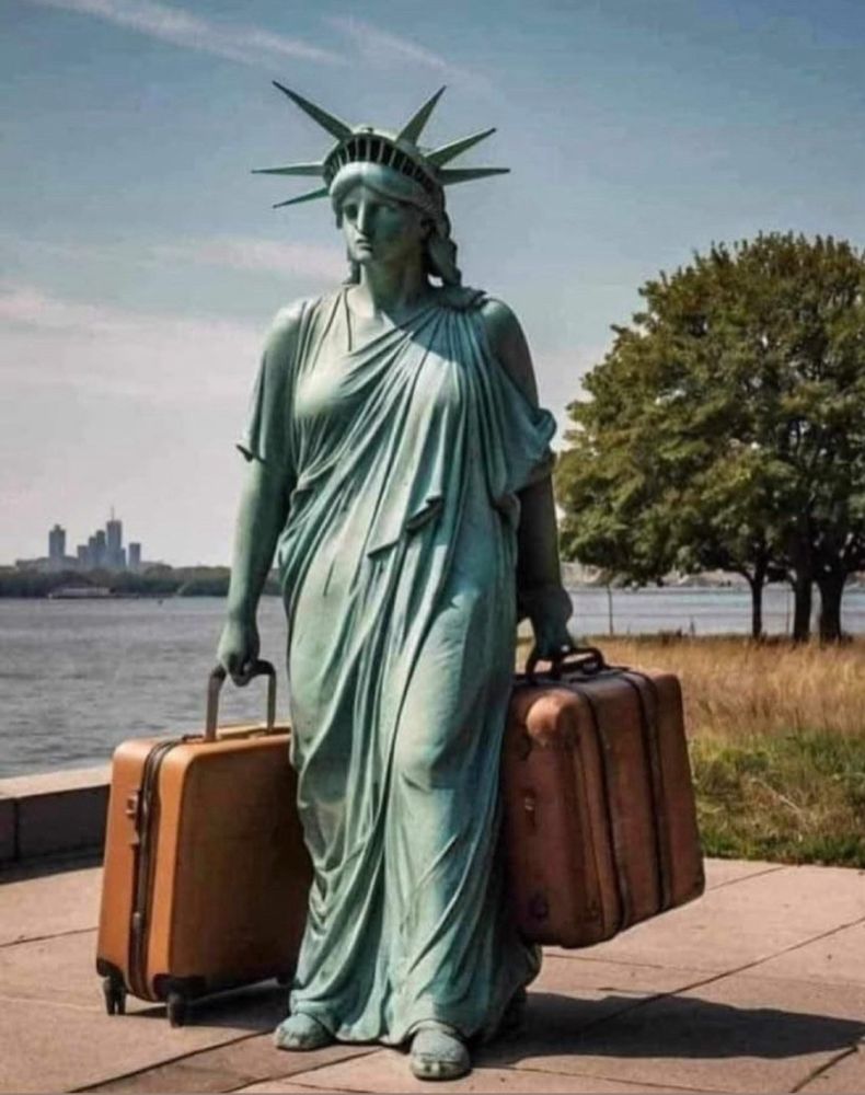 Photo de la statue de la liberté qui tient à sa droite une valise à roulettes et à sa gauche une grosse valise. Au milieu de l'image un fleuve. En arrière plan à gauche, des immeubles 