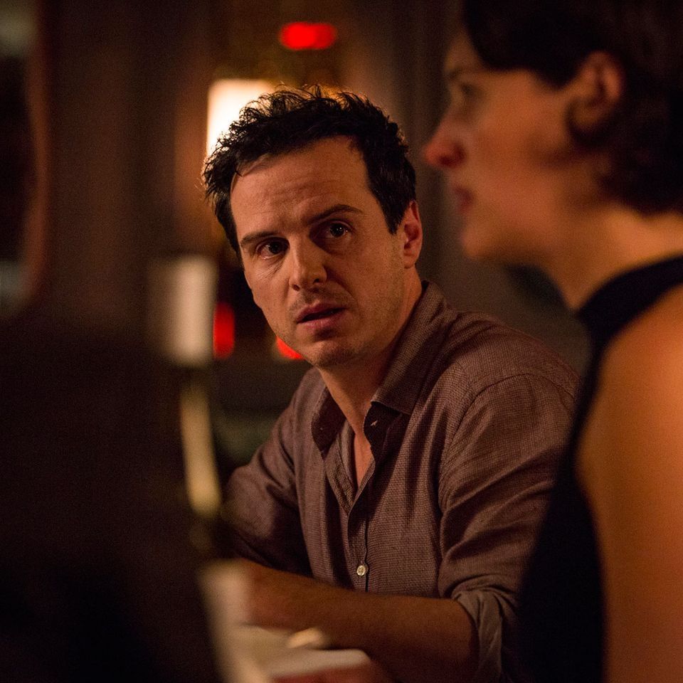 Andrew Scott as the hot priest in fleabag looking kinda disheveled, looking sideward towards the right of the camera where fleabag is visible as a blurry figure 