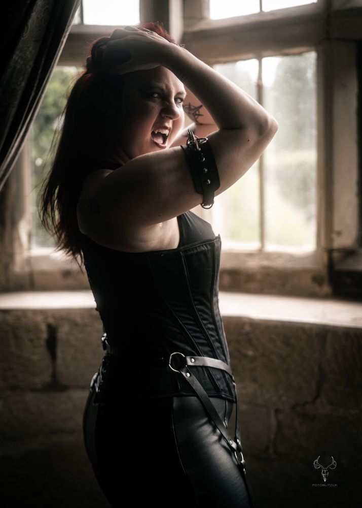 A vampire standing in front of a window.