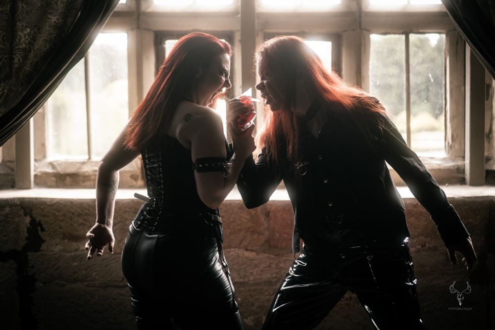 A female vampire and a male vampire fighting over a blood bag. 
