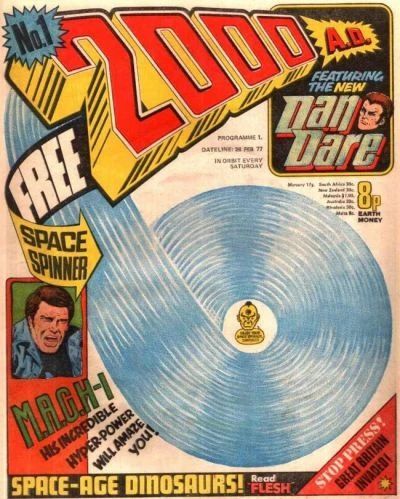 Here is a description of the image:

The image shows the cover of the first edition of the comic book "2000 AD", which was released in 1977. The cover is colorful and eye-catching, with a variety of text and images.

At the top of the cover is the title of the comic book, "2000 AD", in large, bold letters. The letters are red with a yellow outline. A blue starburst with the text "No. 1" sits on the top left. Below the title is the tagline "Featuring the New Dan Dare," and an image of a man.

The cover also features a large image of a blue space spinner which is offered as a "Free Space Spinner". Below that, there is a smaller image of a man with a panicked expression. The text next to the image reads "M.A.C.H-1 His Incredible Hyper-Power Will Amaze You!"

At the bottom of the cover, there is the text "Space-Age Dinosaurs! Read Flesh". On the bottom right of the cover, there is a red box with the text "Stop Press! Great Britain Invaded!". The price of the comic book is listed as 8p in Earth money.
