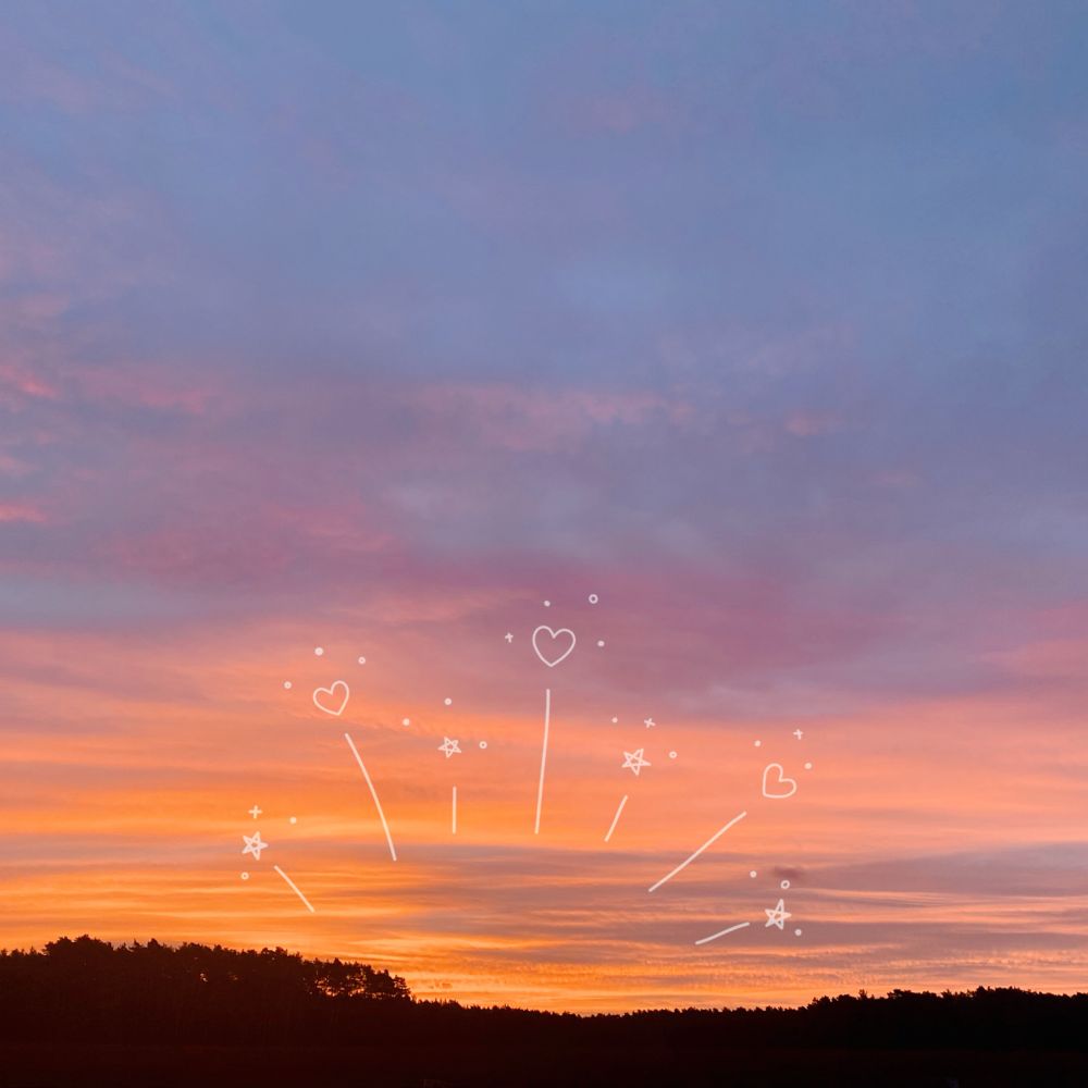 photo of a golden sunrise over a dark forest. a semi-opaque sticker that imitates sunrays has been added as decoration. this is the first sunrise of the new year.