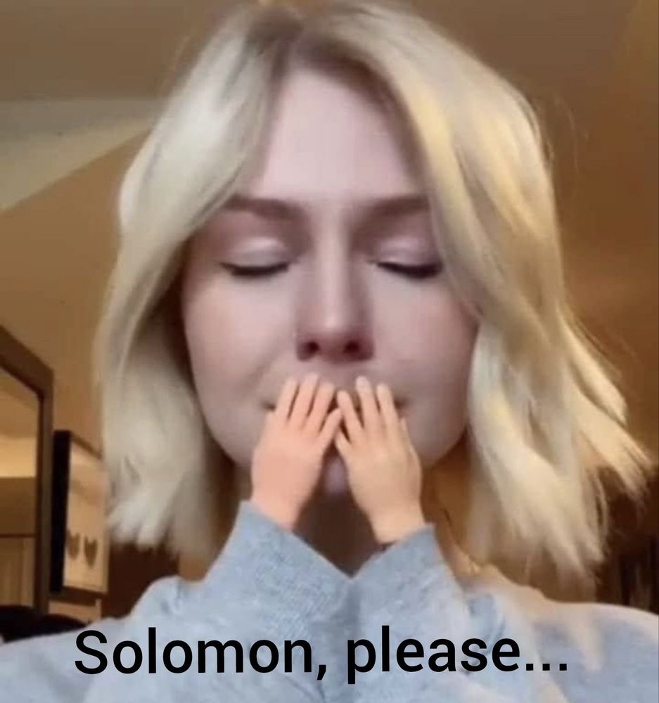 a white woman with short wavy blonde hair wearing a grey sweatshirt holds up a pair of tiny white hands to her lips, her eyes closed as she appears to be crying. in front of her in black text are the words "Solomon, please..."