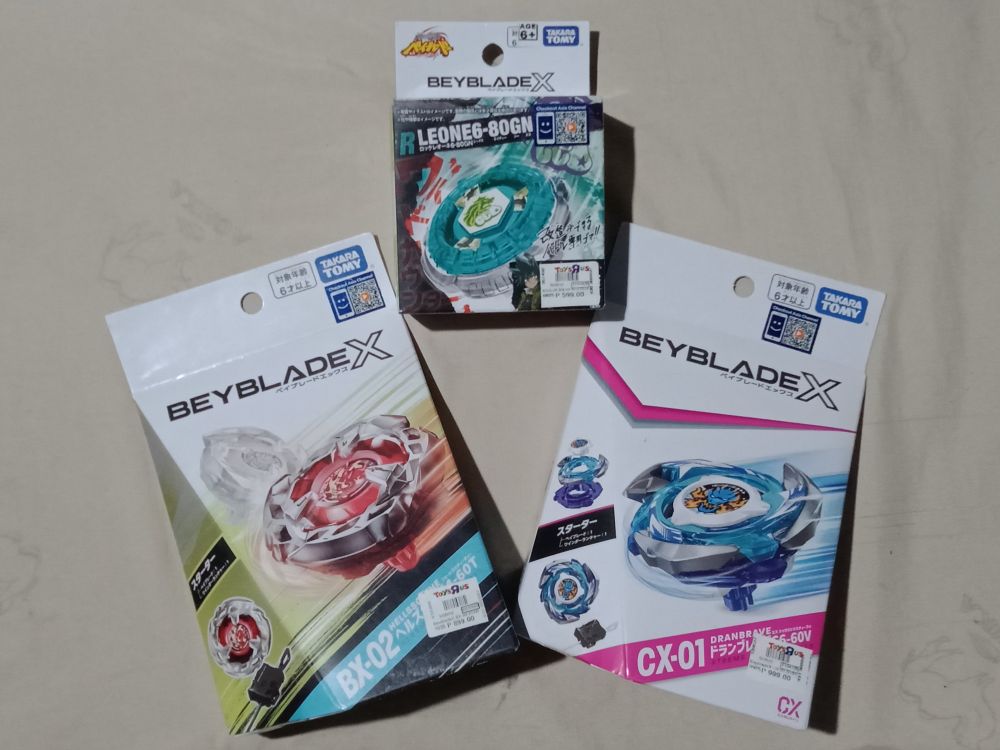 BEYBLADES IN THIS PHOTO

Top: Rock Leone 6-80GN
Bottom Left: HellsScythe 4-60T
Bottom Right: DranBrave S6-60V