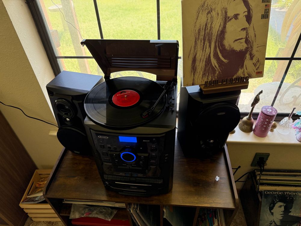 Black stereo with turntable playing a vinyl record