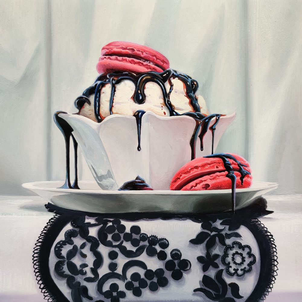Oil painting of a white cake like dessert covered in a dark black drip glaze. The dessert is contained in a decorative china and is accompanied by two macaroons that are a vibrant magenta. All items sit on top a black lace doily 