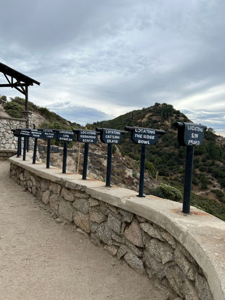 Signs on the pipes from left to right:
“Locating Pasadena”
“Locating Ostrich Farms”
“Locating Silverlake”
“Locating Los Angeles”
“Locating Redondo Beach”
“Locating Catalina Island”
“Locating the Rose Bowl”
“Locating San Pedro”