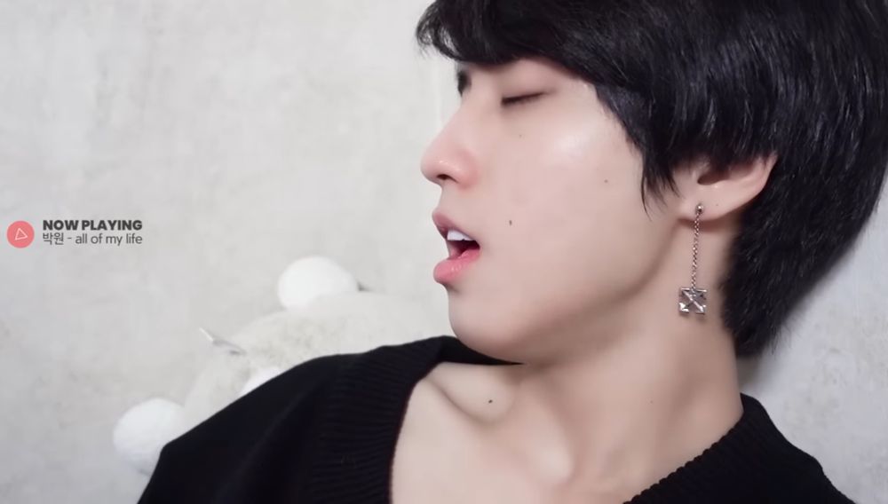 jisung singing with his eyes closed in a shirt that shows off his collarbone and neck