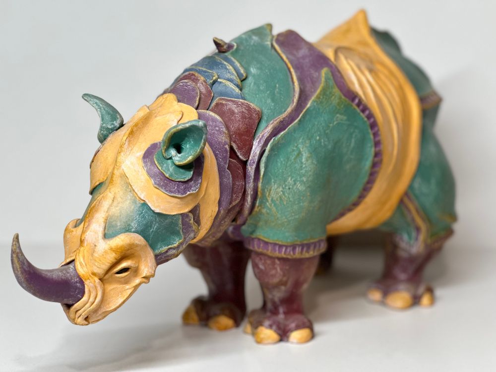 A side view of an Indian rhino from the left, based on Albrecht Durer’s 1515 engraving. This one is made of polymer clay and polychromed in shades of yellow, green and purple
