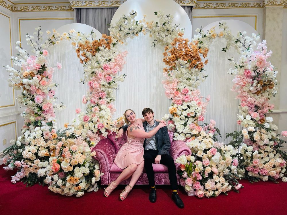 Sophie & I sitting on a pink couch among many many flowers