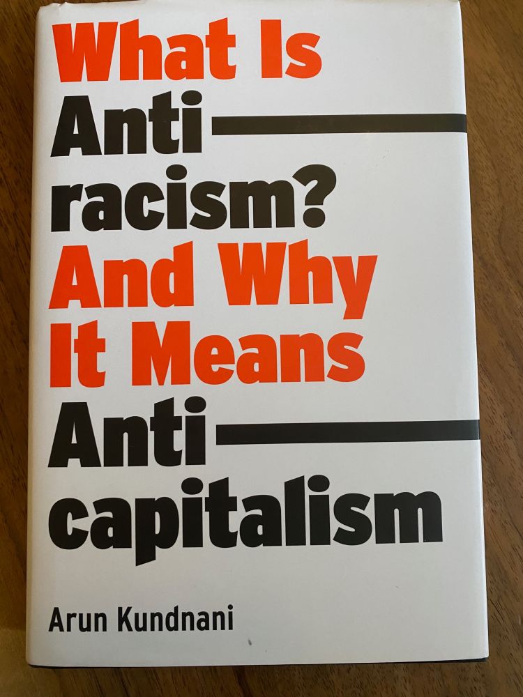 photograph of a book cover: "What IS Anti-racism and why it means anti-capitalism" by Arun Kundnani. White cover with black and red letters. Behind it is a wooden table.
https://www.versobooks.com/products/2670-what-is-antiracism?srsltid=AfmBOopot3KVoIBpOhnF5ptCyj1W7dLfu1i7AIPAKe6DqIUGzNFSe9eK