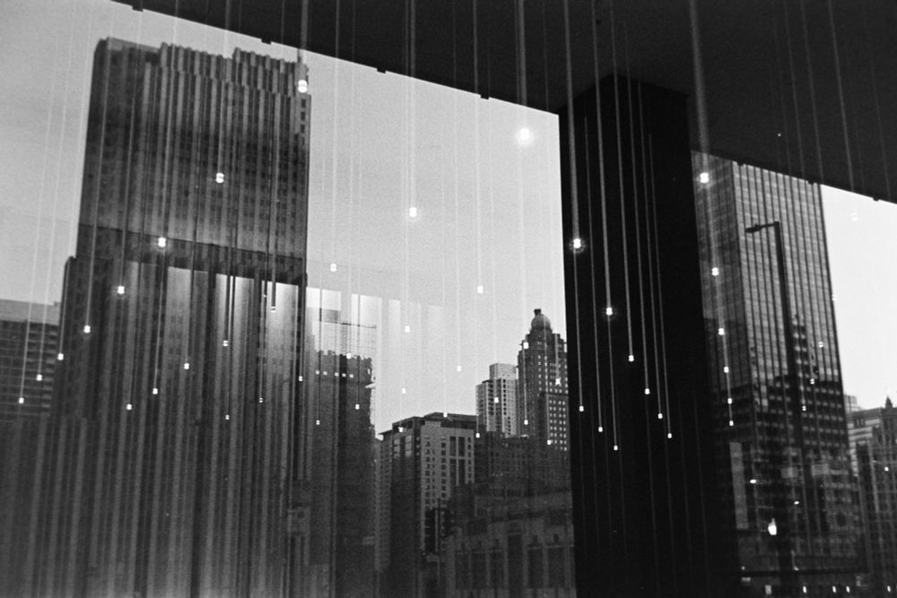 reflection of Chicago skyline in a window with an array of lights