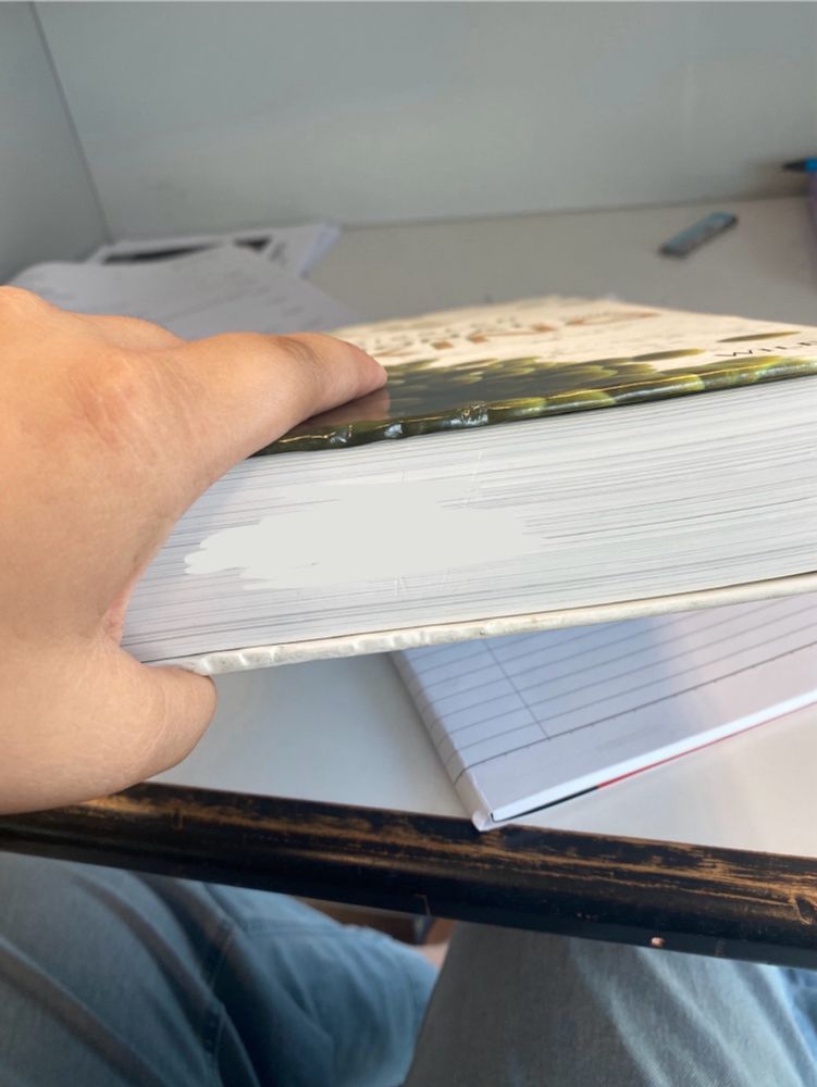 A person (me) holding a text book on about food studies in culinary