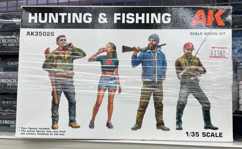 A 1/35 scale model set turned hunting & fishing, containing 4 Caucasian people: a man with a hunting rifle in a sheath over his shoulder, drinking from a flask. A woman in jean shorts and a crop top drinking a can of coke. A bearded man in a denim jacket and beanie hat with a rifle over his shoulder. A man with a red baseball cap with the letter A on it, pulling in something on his fishing line 