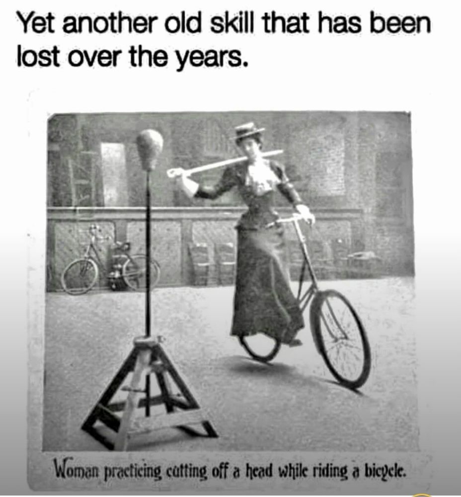 Black and white vintage image of a woman in full Victorian dress, practicing cutting the head off of a dummy while riding a bicycle. Caption reads, "Yet another old skill that has been lost over the years."
