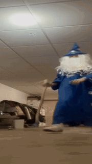 a person dressed as a wizard is using a vacuum cleaner in a garage