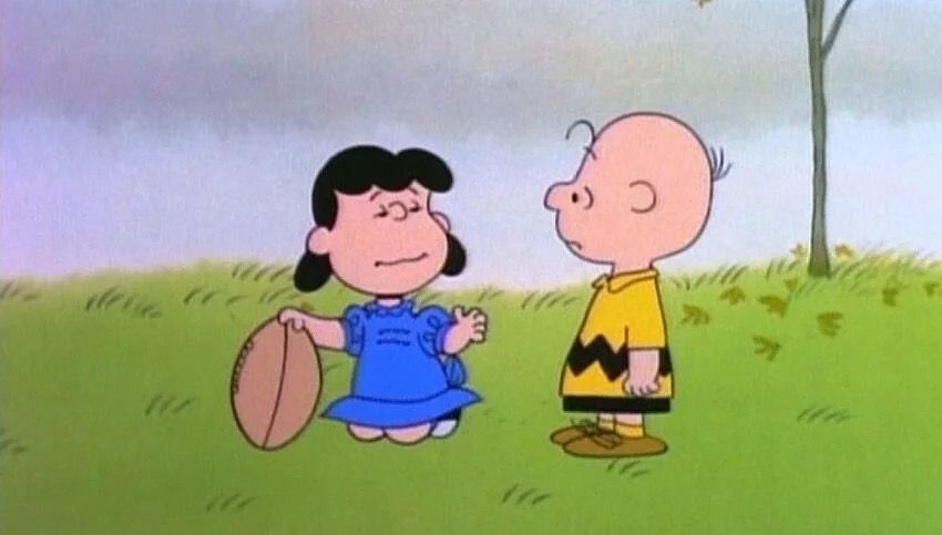 Lucy holding a football for Charlie Brown.