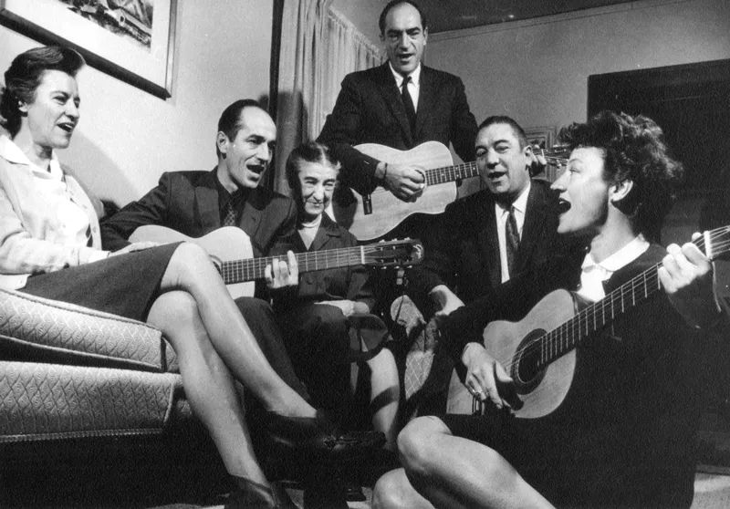 A group of men and women singing and some with guitars. Luna Leopold, a famous geomorphologist is the one standing among his family. Photo is from the Aldo Leopold Foundation (dated 1966) 