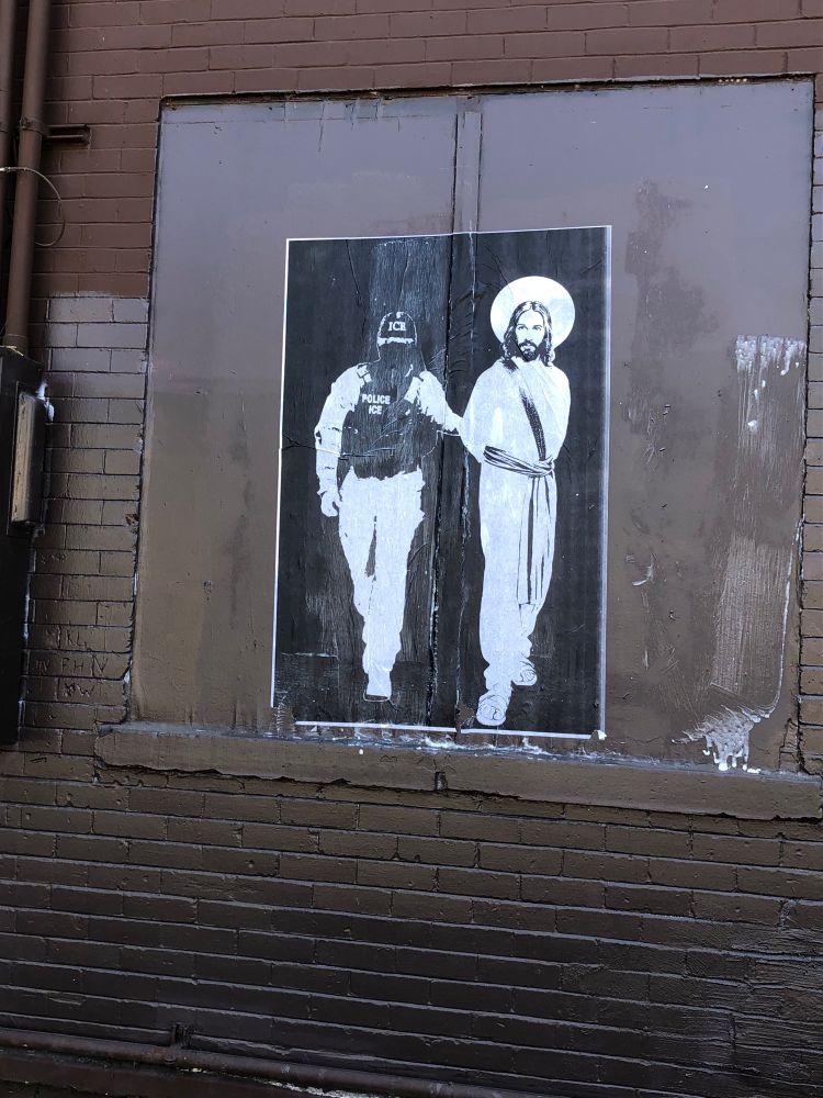 Graffiti art poster showing an ice agent arresting Jesus in white on black 