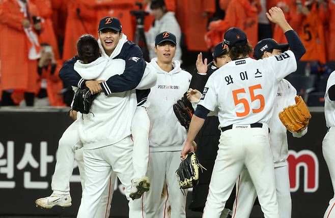 Photo of Hanwha Eagles players celebrating on the field following a win. One player leapt into another's arms. Photo by Yonhap News