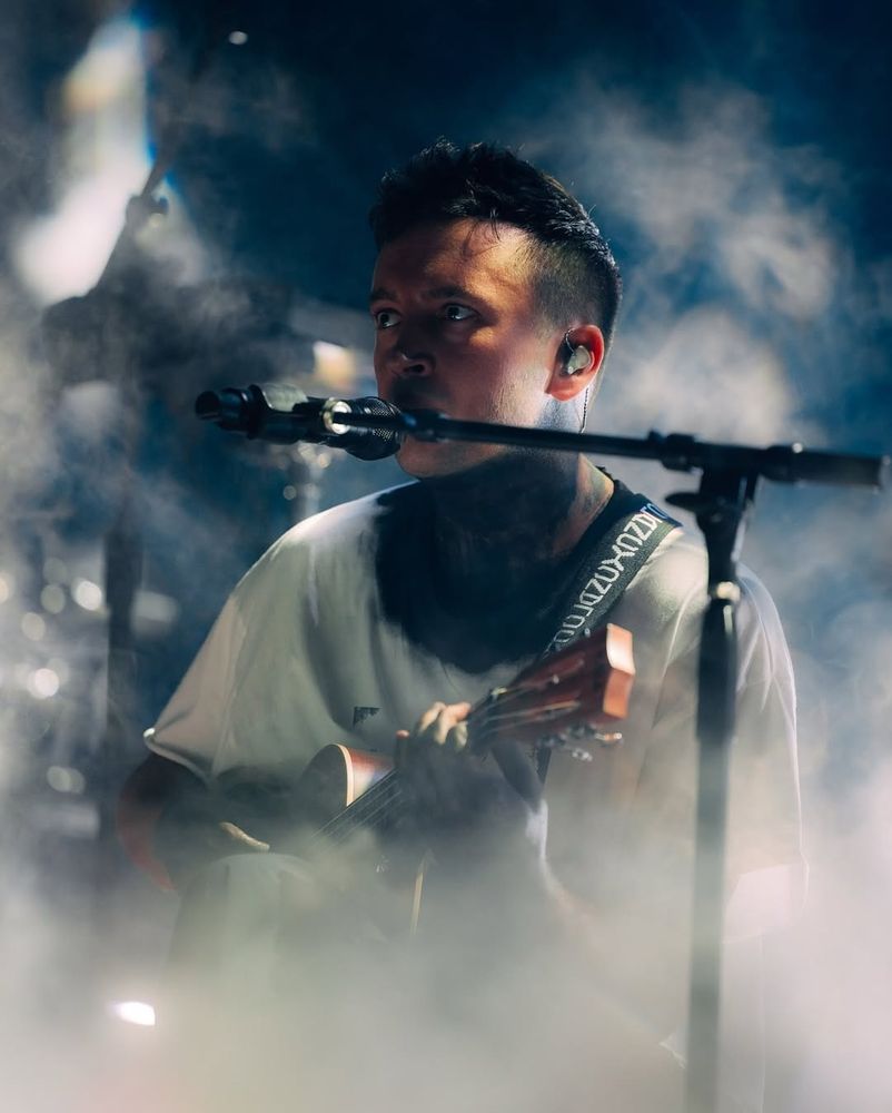 Tyler Joseph playing ukulele and singing into a microphone during Clancy tour. 