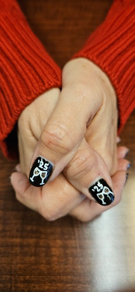 Thumb nails painted black with two champagne flutes being clinked together with a '25 above them.
