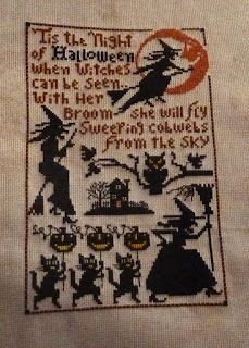 "Sweepingh Cobwebs" by the Prairie Schooler.  "Tis the night of Halloween when witches can be seen...with her broom she will fly sweeping cobwebs from the sky". A witch flies on her broom across a smiling copper moon while another witch sits by a tree branch with an owl and a third witch marches across the bottom leading a parade of cats holding lighted jack-o-lanterns on sticks. Cross stitch and backstitch on tea dyed 18ct aida.
