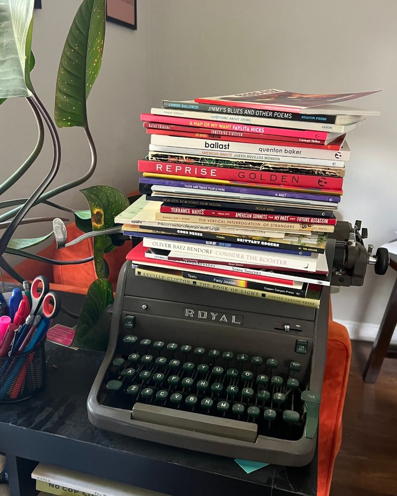 A stack of 31 books atop a typewriter.

Blood-Flex by Ajanaé Dawkins

Jimmy's Blues and Other Poems by James Baldwin

Something About Living by Lena Khalaf Tuffaha 

A Map of My Want by Faylita Hicks

Something Sinister by Hayan Charara

Citizen Illegal by José Olivarez

Ballast by Quenton Baker 

American Inmate by Justin Rovillos Monson

Some Changes by June Jordan

Reprise by Golden

Portrait of the Alcoholic by Kaveh Akbar

There Are Trans People Here by H. Melt

Abalone ((animus)) / abalone ((anima))by fahima ife

Florida Water by aja monet

Dear God. Dear Bones. Dear Yellow. by Noor Hindi

The Word From His Song by Li-Young Lee

American Sonnets for My Past and Future Assassin by Terrance Hayes 

Vertical Interrogation of Strangers by Bhanu Kapil

Somebody Blew Up America by Amiri Baraka

This Connection of Everyone with Lungs: Poems by Juliana Spahr

 Good Dress by Brittany Rogers

Those Who Ride the Night Winds by Nikki Giovanni

Nazar Boy by Tarik Dobbs

Consider the Rooster by Oliver Baez Bendorf

Togethering by Rose Zinnia

Homegirls & Handgrenades by Sonia Sanchez

A box of longing with fifty drawers by Jen Benka

Time Slips Right Before Your Eyes by Erica Hunt

Textu by Fady Joudah

The Book of Light by Lucille Clifton

Beast / Meridian by Vanessa Angélica Villarreal