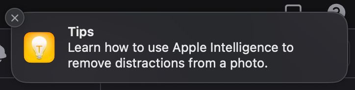 A macOS notification saying "Tips: Learn how to use Apple Intelligence to remove distractions from a photo."