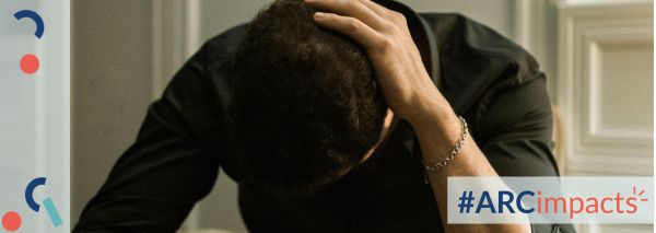 Person looking down and holding their head. #ARCimpacts logo