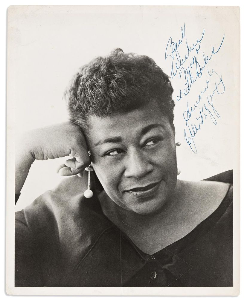 Bust portrait of Ella Fitzgerald facing camera and looking to one side.