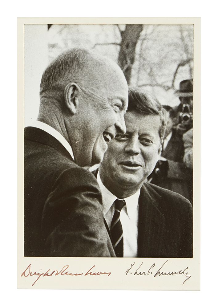 Photograph showing President Eisenhower and President-Elect Kennedy talking, with their signatures written in the lower margin.