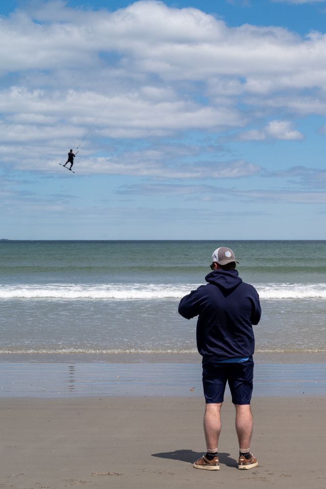 Man watching a kite surfer getting some air