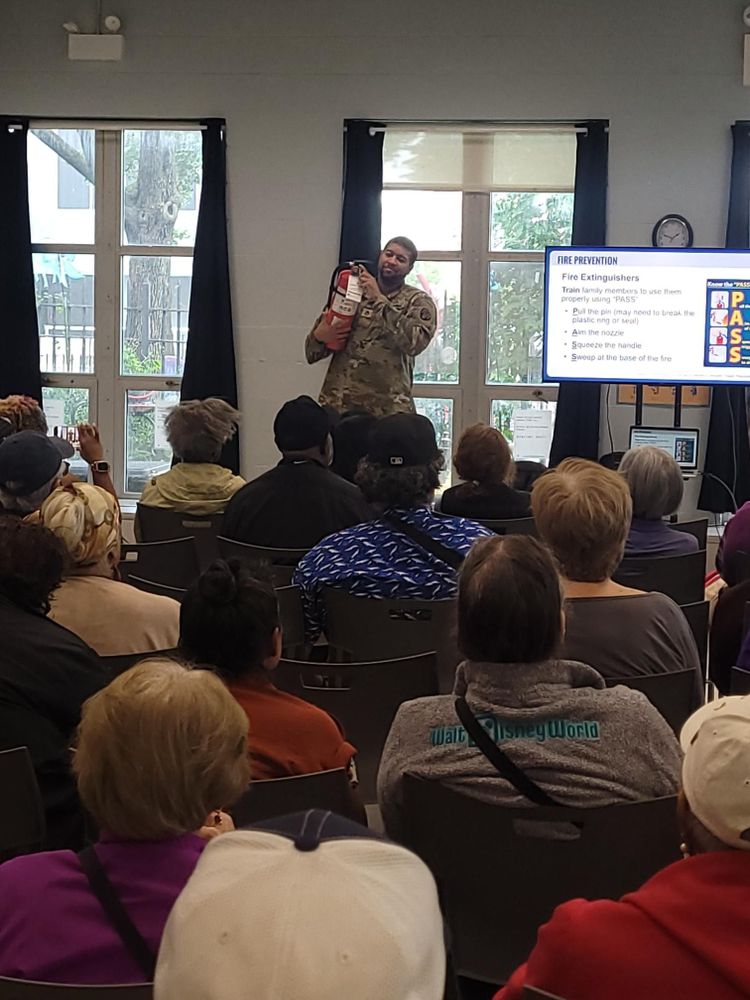 Presentation on emergency preparedness with person showing how to use a fire extinguisher