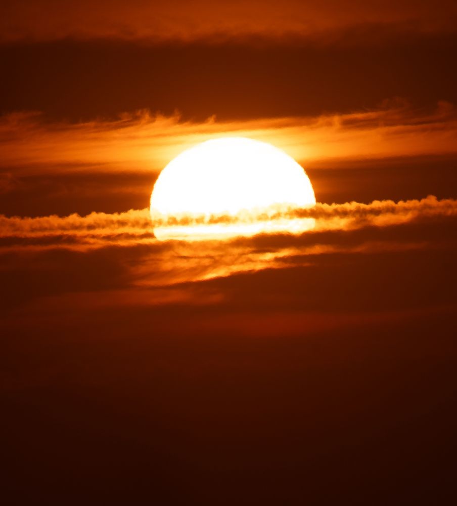 The sun setting behind clouds 