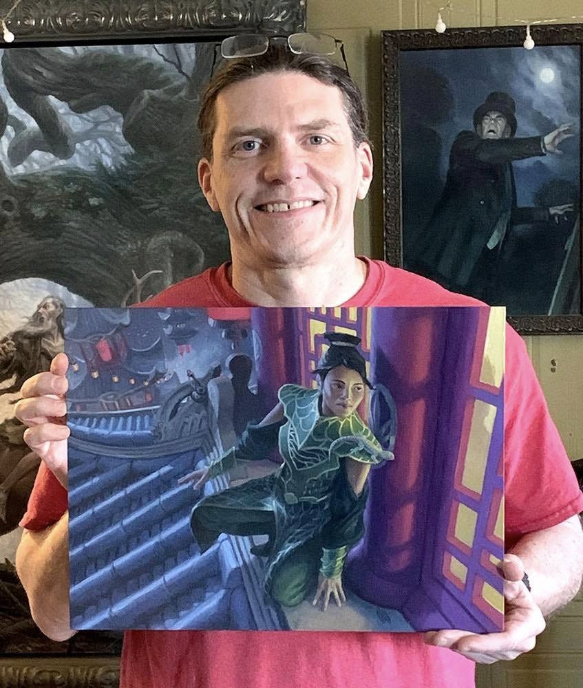 artist matt steward holds his new painting, agent of kotis