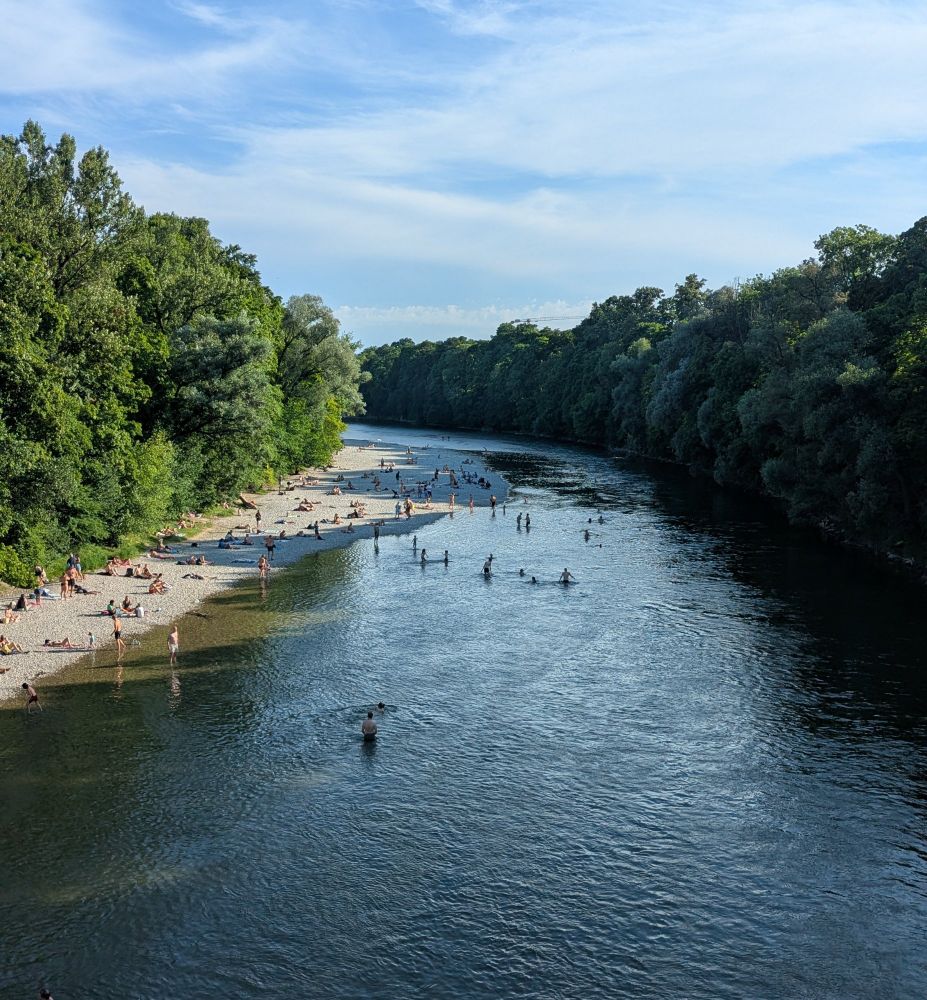 Foto von einer Brücke auf einen Fluss. Unten eine Kiesbank und Badende.