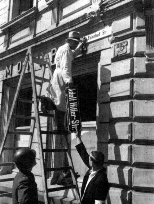 Workers removing the sign from the former Adolf Hitler Street in Trier, Germany, in 1945 after the defeat of Nazi Germany.