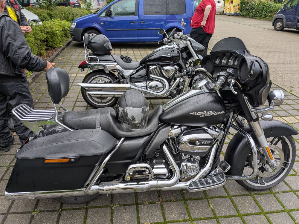 Bild von zwei Harley-Davidson-Motorrädern, hier im Fokus: Eines mit Windschild und Heckkoffern