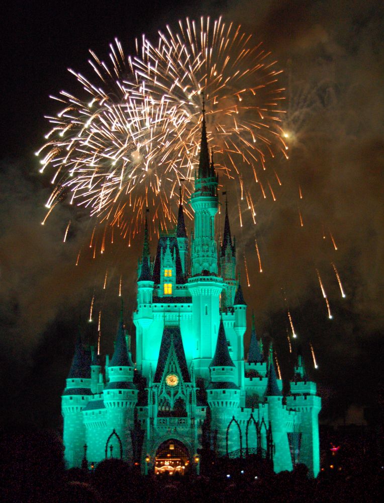 Photo of fireworks exploding over a green tinted Cinderella Castle.