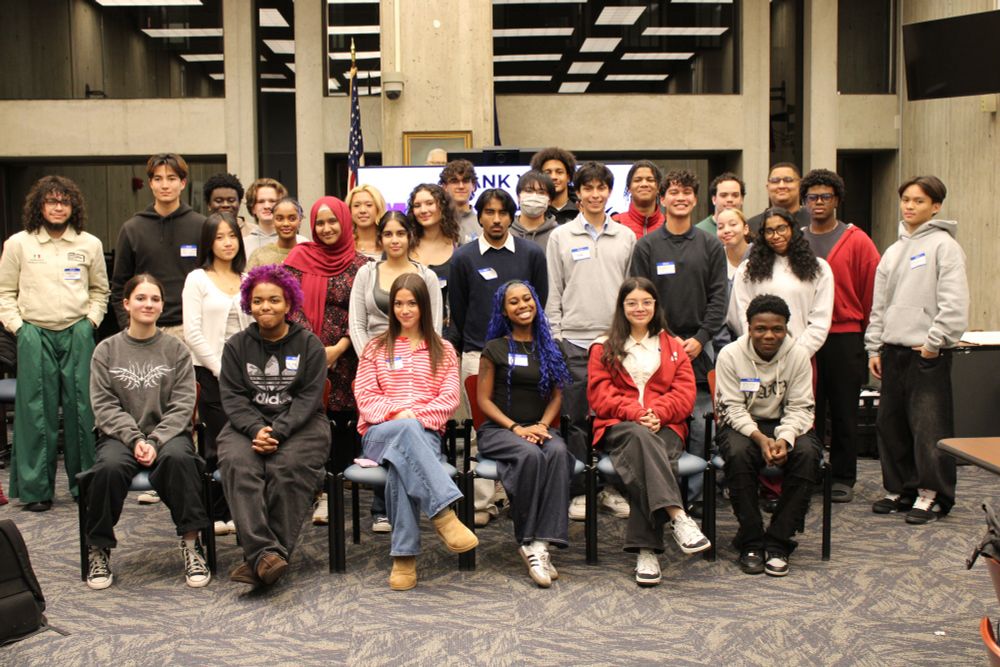 30 youth smile and pose for the camera, standing in three rows