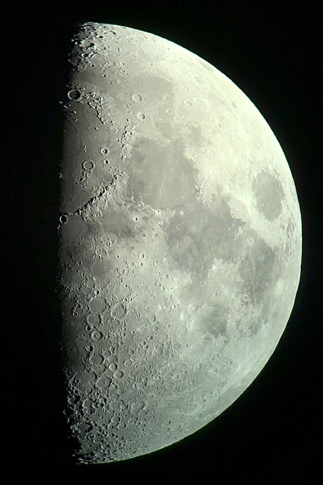 A close up image of the first quarter moon, featuring craters and lunar maria 